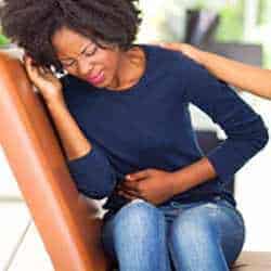 mujer con dolor de estómago por gastroenteritis